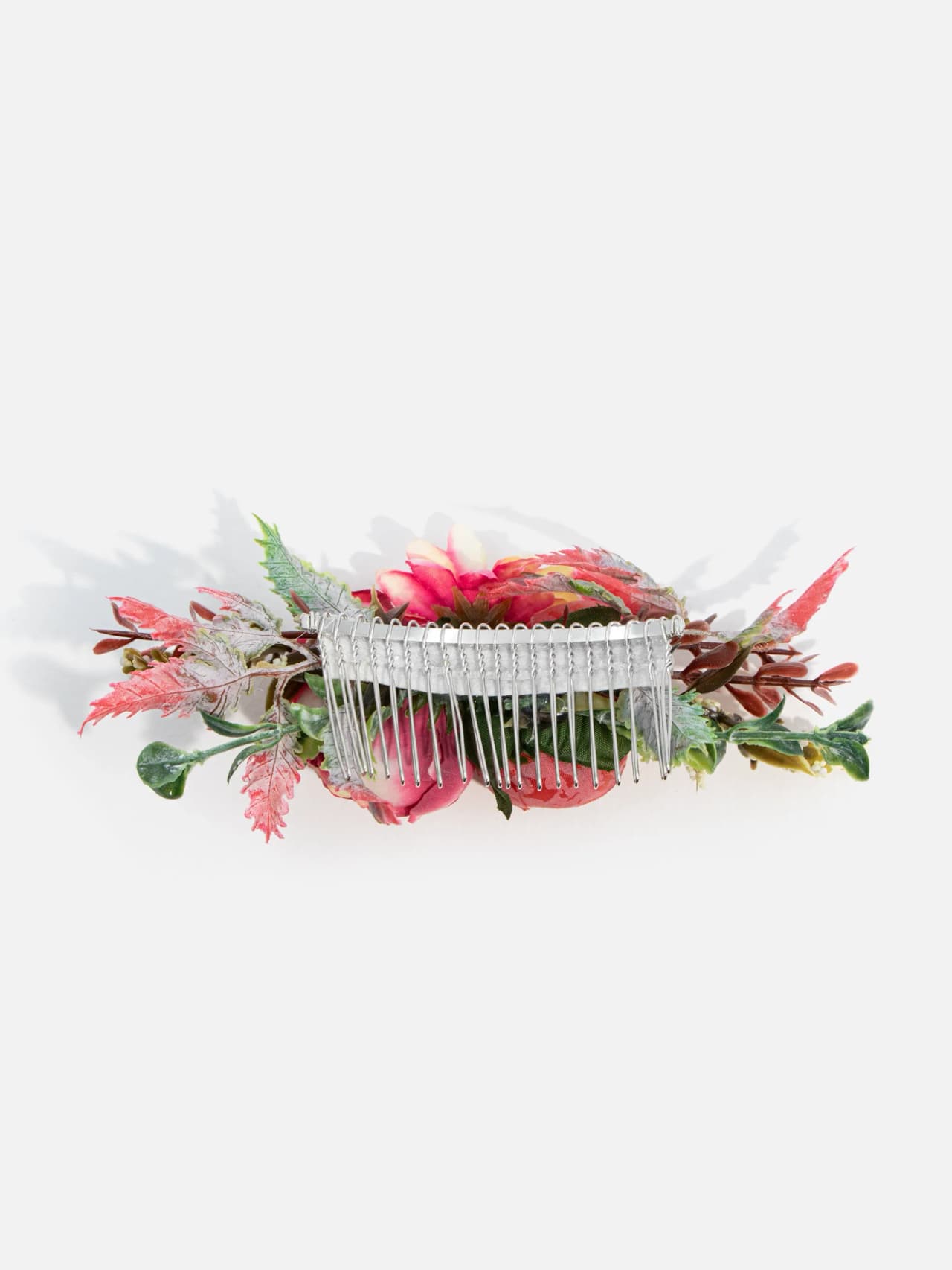 Baksida av blommig hårkam med flexibel silverfärgad metallkam och gröna blad