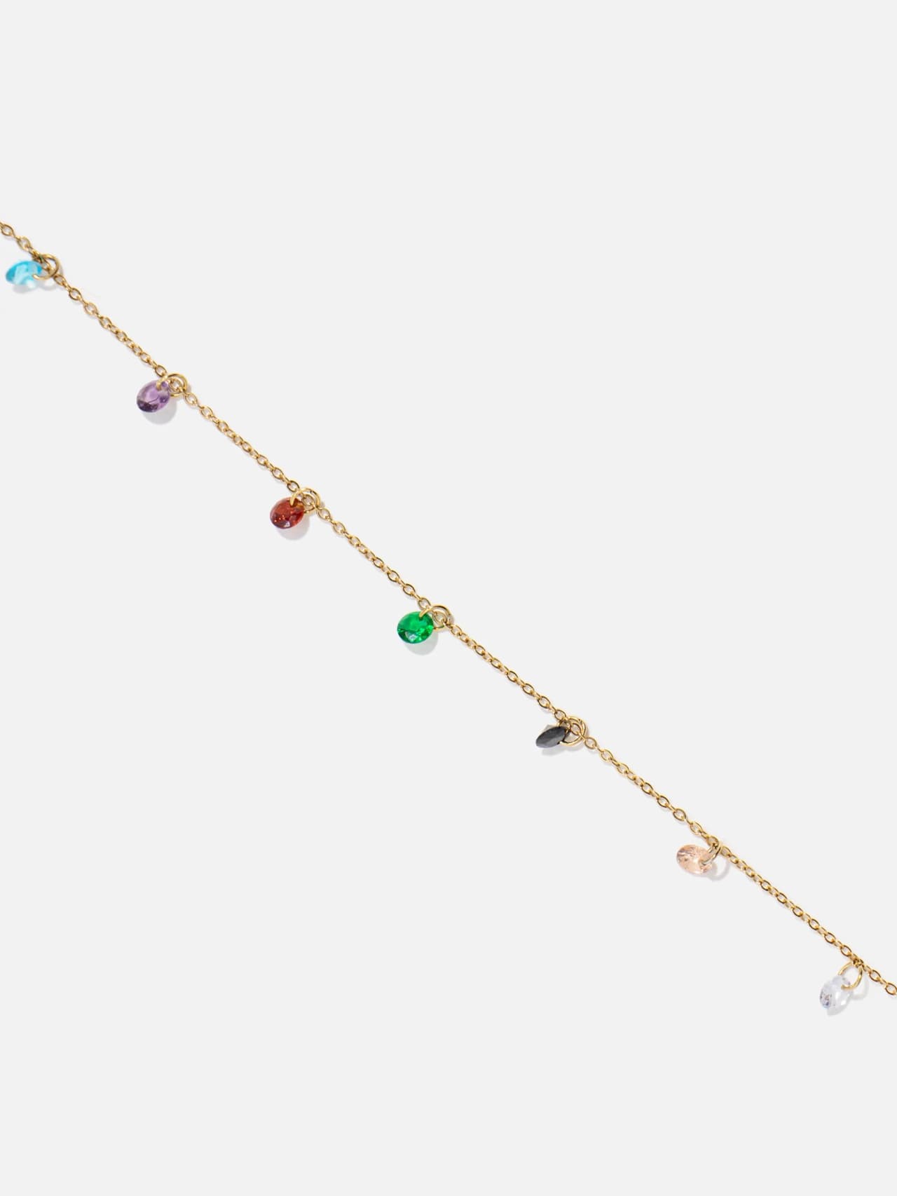 Närbild på multicolor fasetterade kristallberlocker på guldkedja