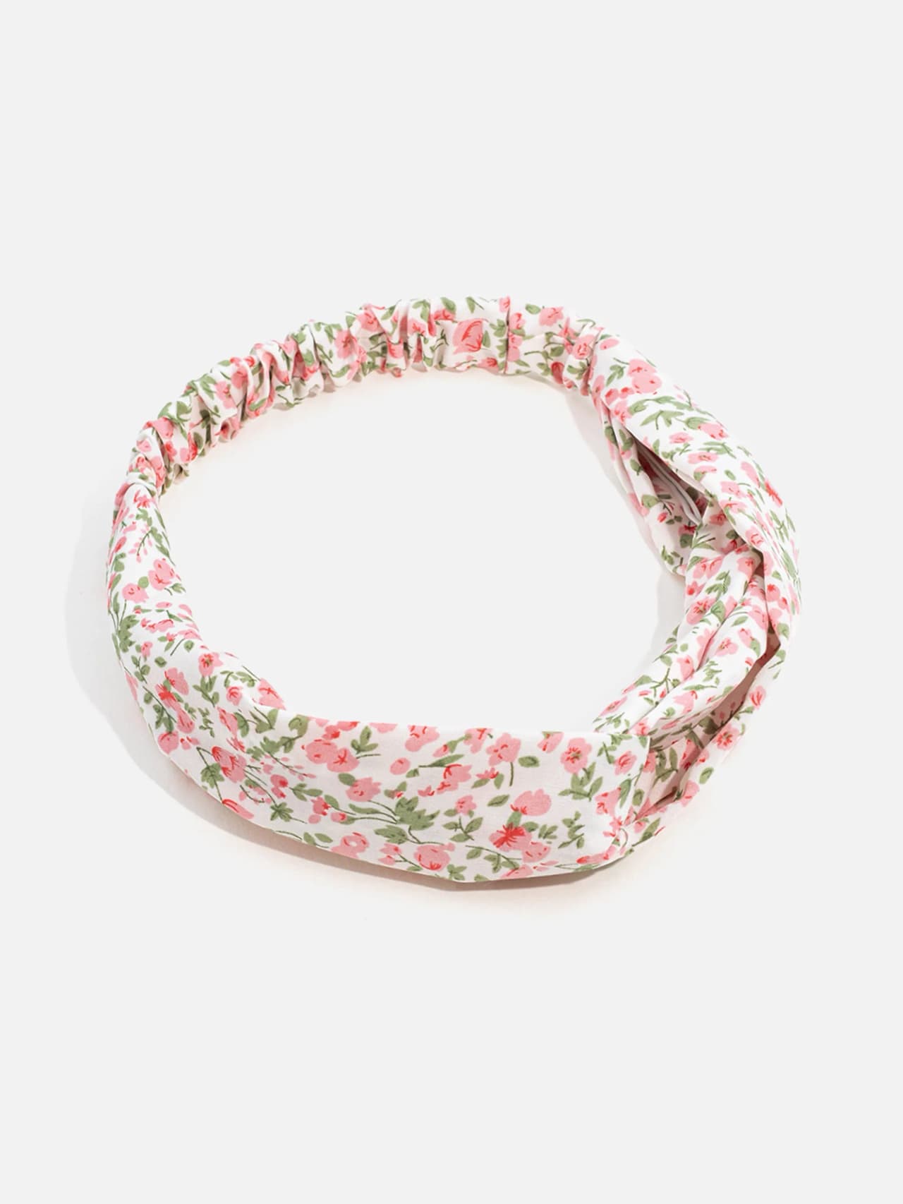 Knutat hårband med rosa rosor och gröna löv på vit botten