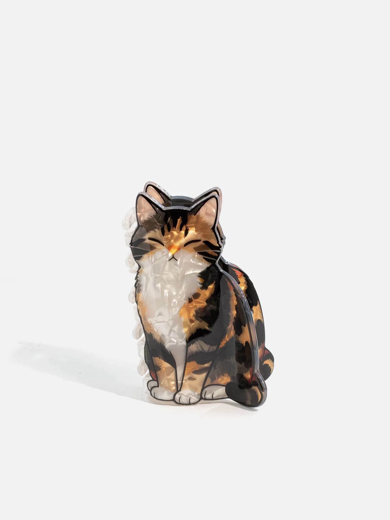 Hårklämma med sittande/framställd kattmotiv framifrån på vit bakgrund