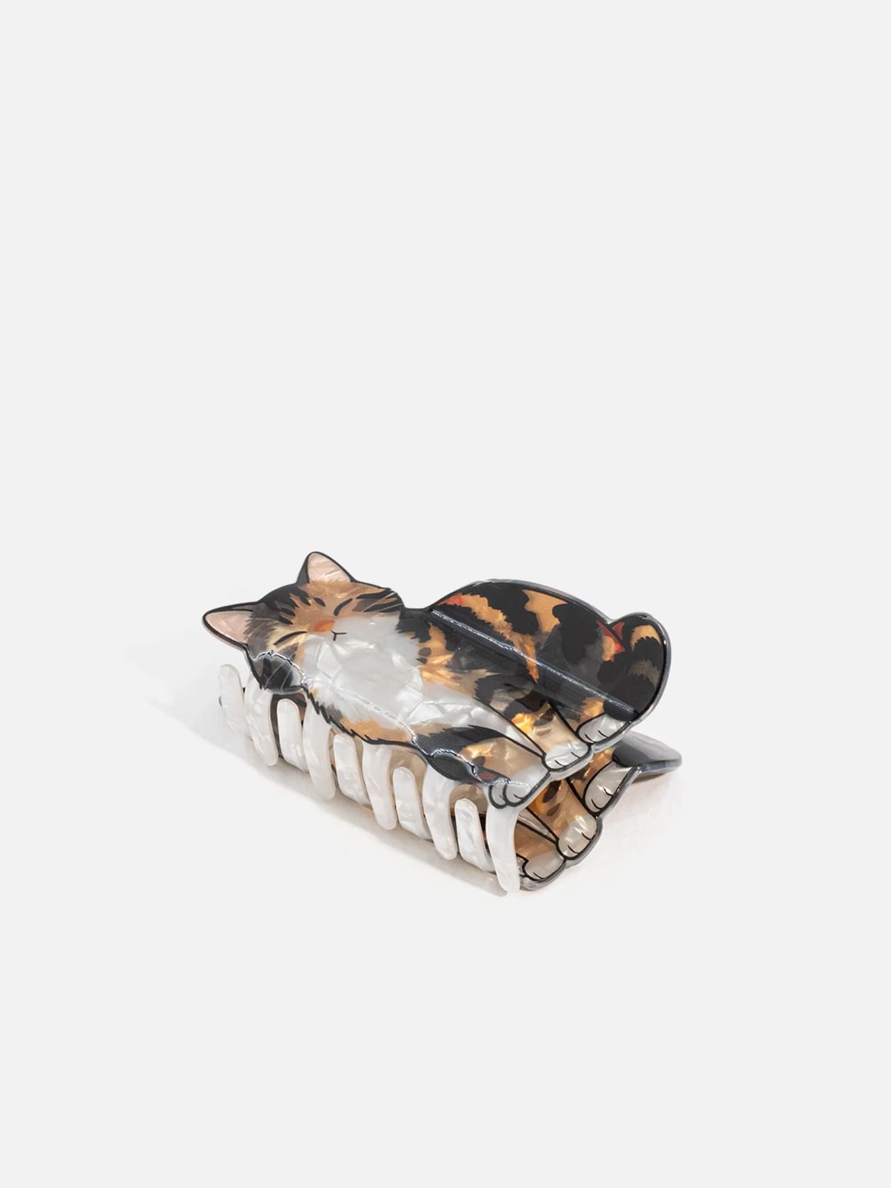 Hårklämma med liggande kattmotiv i trefärgat mönster, sidovy