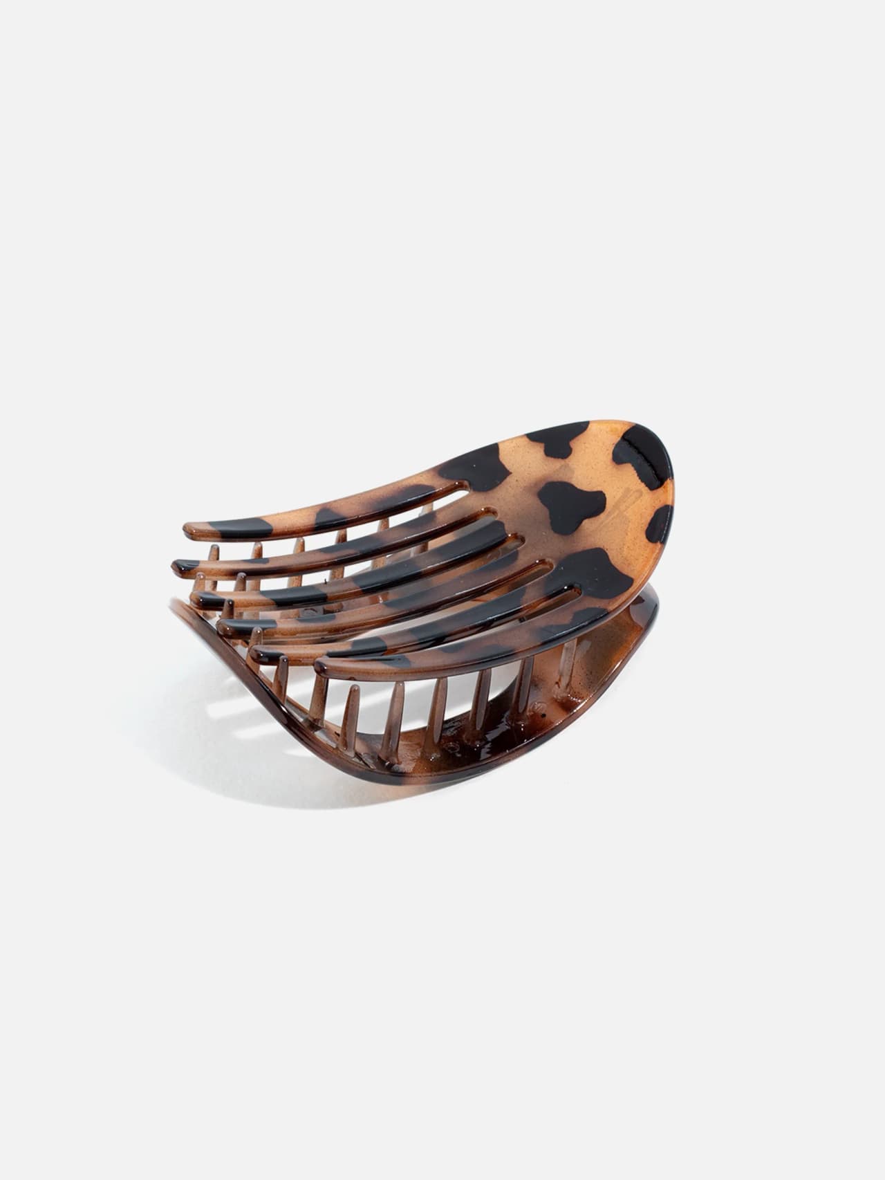 Närbild underifrån av oval hårklämma med brunt leopardmönster