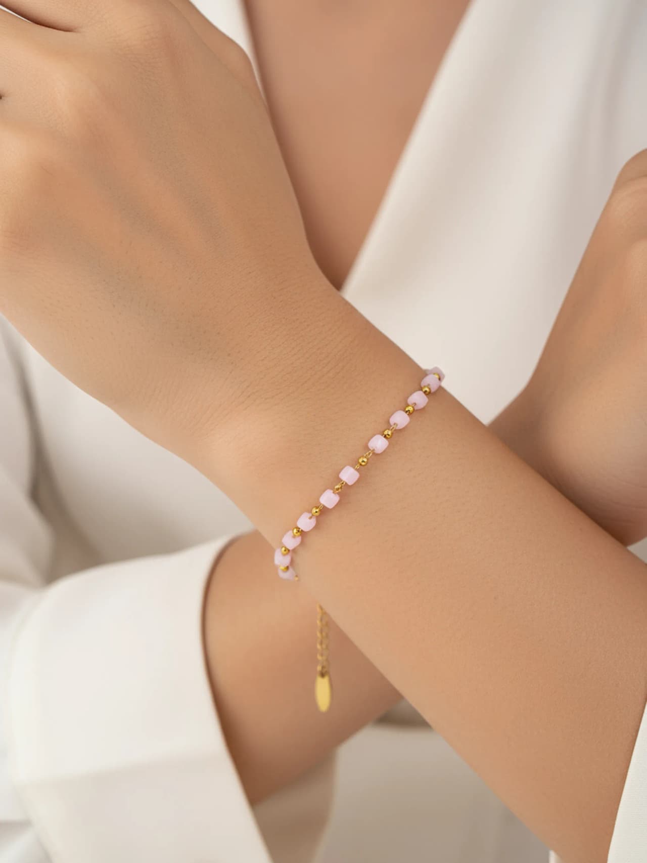 Pärlarmband med rosa kristallkuber och guldkulor i 18K guldpläterat rostfritt stål i model hand
