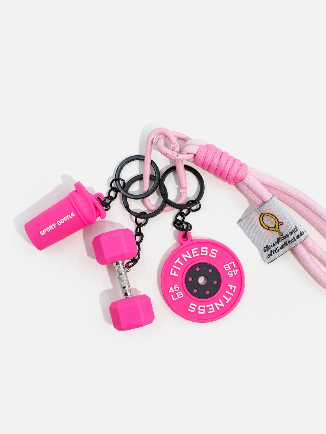 Närbild på rosa gymnyckelring med små träningsberlocker och svart kedja