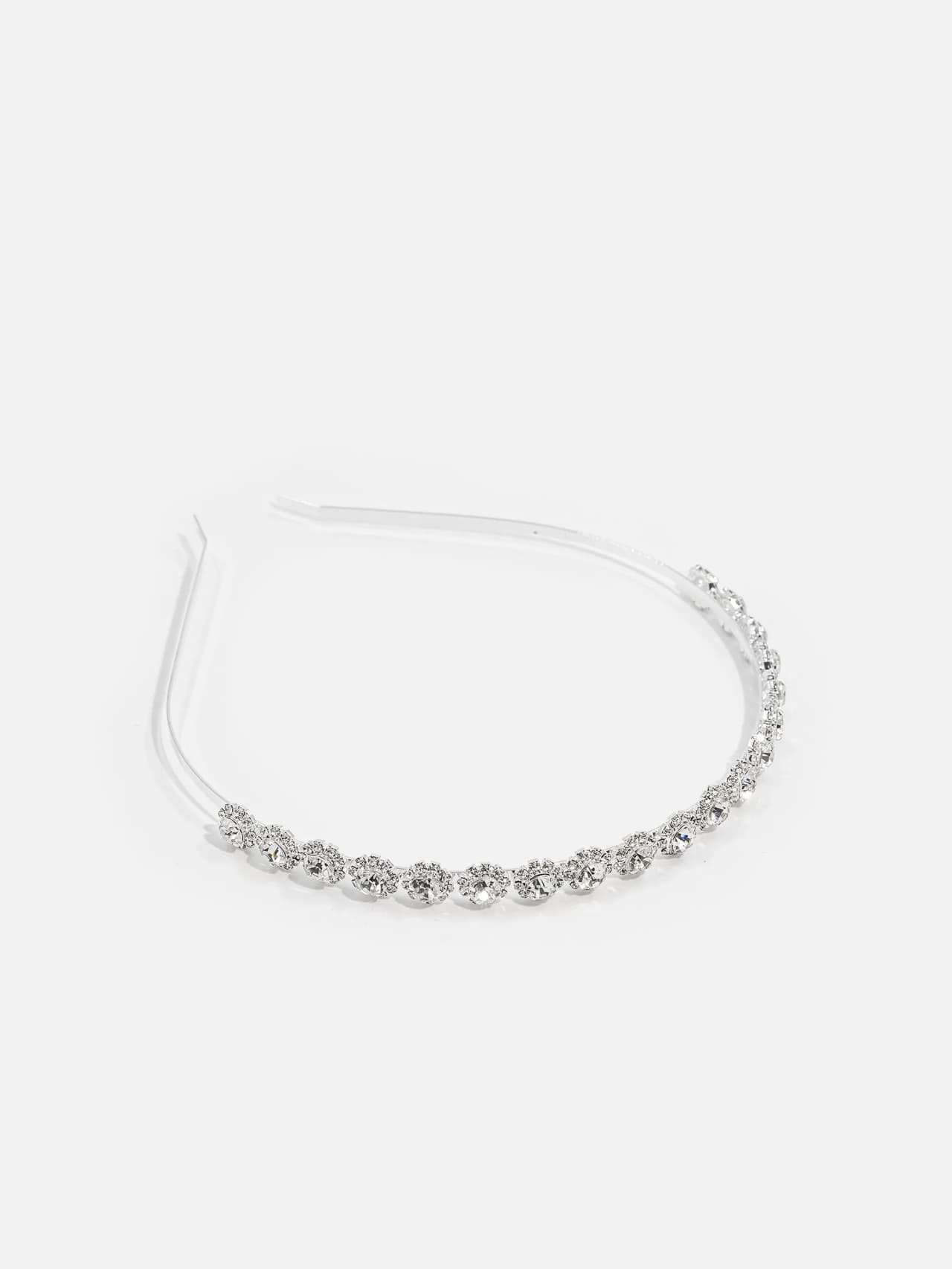 Silverfärgat smalt diadem med rad av klara stenar framtill på vit bakgrund