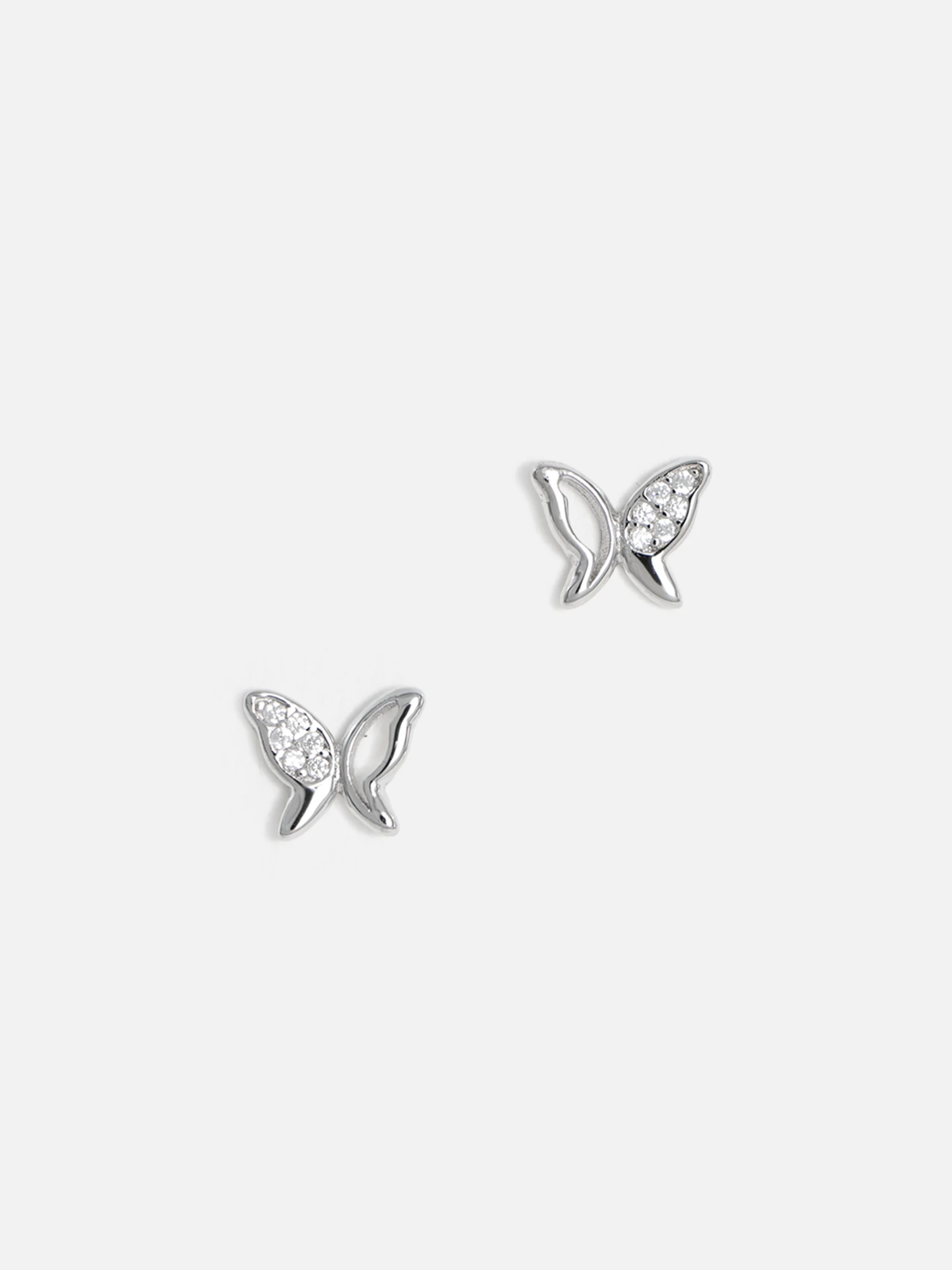 Silverörhängen i fjärilsform med gnistrande cubic zirconia på vit bakgrund.