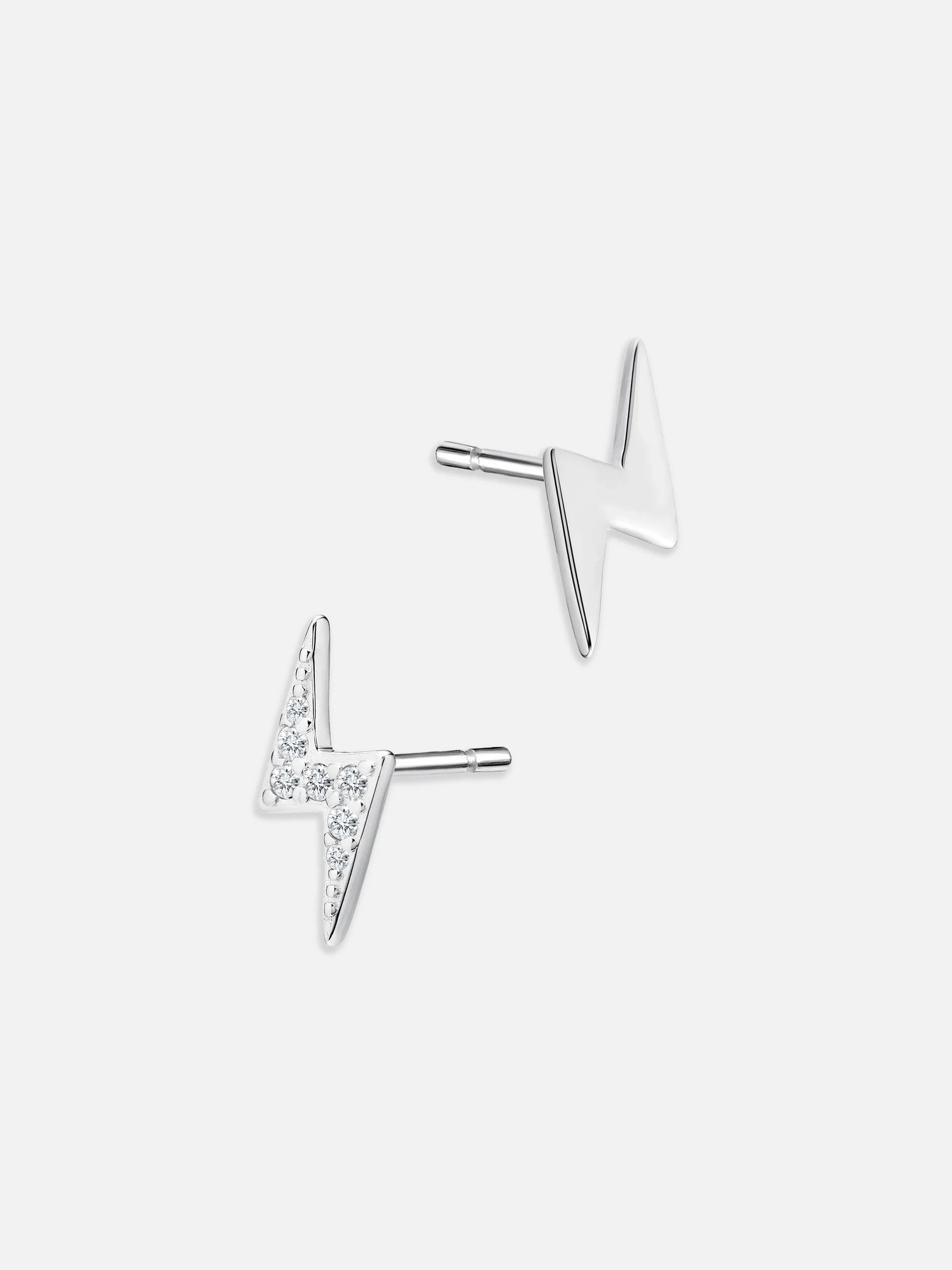Silverblixtar med gnistrande cubic zirconia, örhängen mot mörk bakgrund.